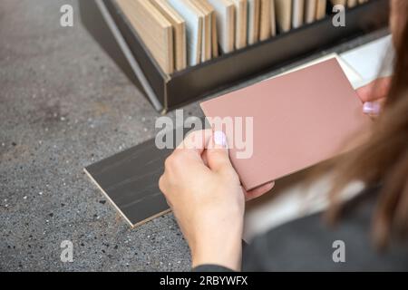 Choice of floor color from wood samples. A female designer chooses a floor color using samples of different shades. The concept of choosing a new Stock Photo