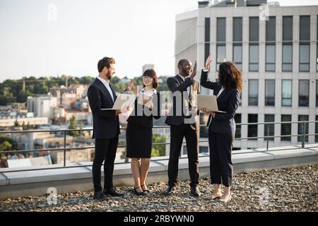 Overjoyed successful diverse employees giving high five at meeting ...