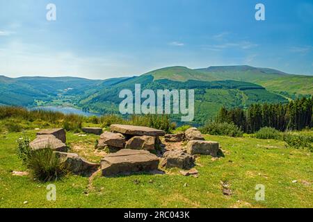 Looking at a stunning view over the stone table and chairs from the local farmer towards the Talybont Valley and reservoir in the Brecon Beacons Stock Photo