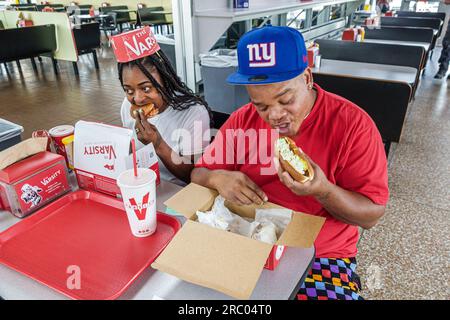 Atlanta Georgia,The Varsity restaurant,inside interior,Black African American man woman couple eating table Stock Photo