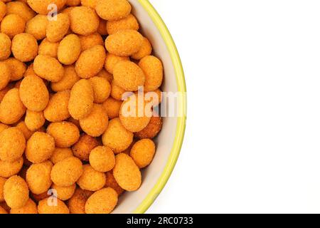 Half bowl full of chili paprika coated peanuts snack isolated on white background Stock Photo