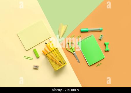 Composition with notebooks and different school stationery on color background Stock Photo
