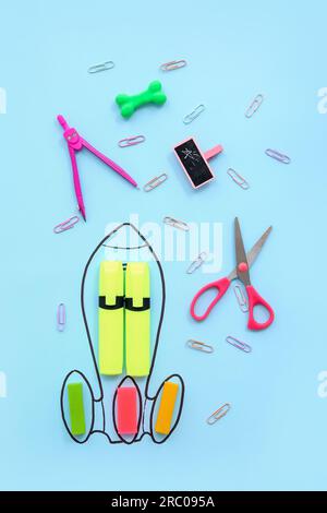 Creative composition with drawn rocket and different stationery on blue background Stock Photo