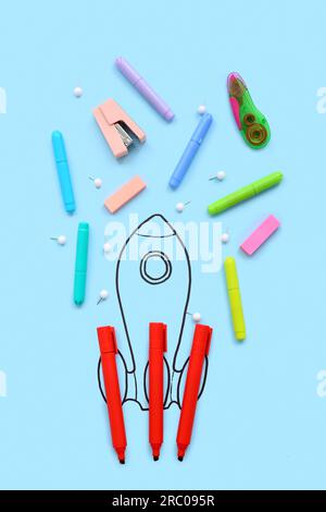 Creative composition with drawn rocket and different stationery on blue background Stock Photo