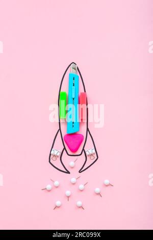Creative composition with drawn rocket and different stationery on pink background Stock Photo