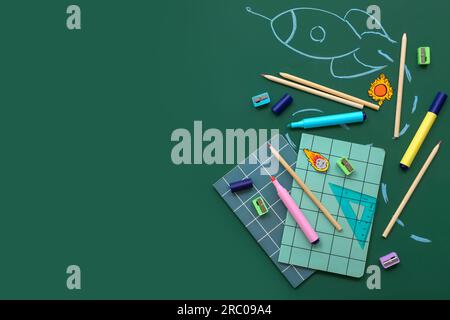 Creative composition with drawn rocket and different stationery on green chalkboard Stock Photo