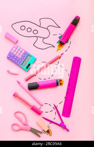 Creative composition with drawn rocket and different stationery on pink background Stock Photo