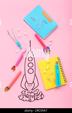 Creative composition with drawn rocket and different stationery on pink background Stock Photo