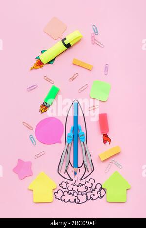 Creative composition with drawn rocket and different stationery on pink background Stock Photo