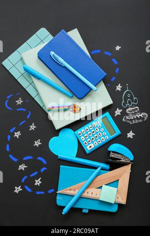 Creative composition with drawn rocket and different stationery on black chalkboard Stock Photo
