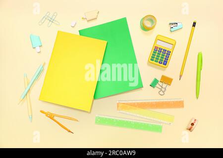 Notebooks with different stationery on pale yellow background Stock Photo