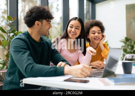 Multiracial students discussing educational project and ideas, studying indoors, sitting in coworking space Stock Photo