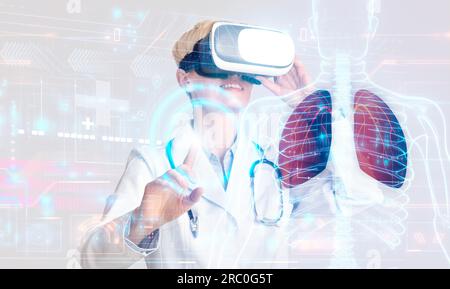 Blonde woman doctor looking at hologram of lungs, using VR Stock Photo