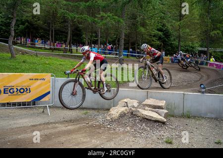 Sina Frei jumps with Jolanda Nef on her back and Pauline Ferrand Prevot on fast turn during 2023 UEC MTB Elite European Championships- European Games Stock Photo