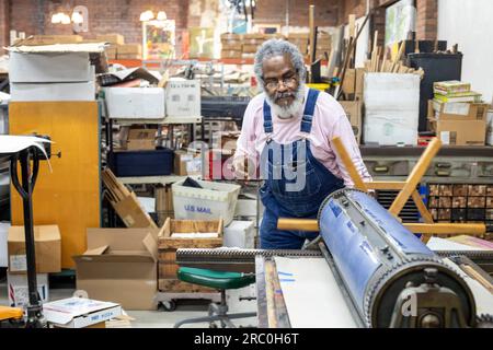 Detroit, Michigan - Amos Kennedy works in his letterpress printing shop. Kennedy prints posters and gives workshops on letterpress printing. Stock Photo