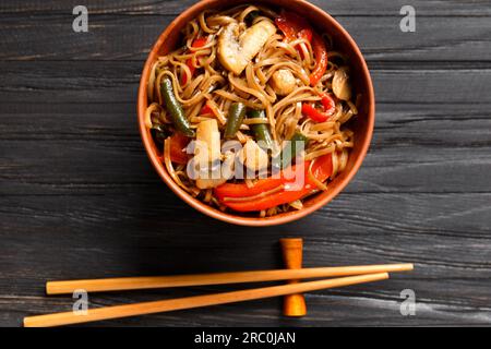 Plate with buckwheat noodles with vegetables, mushrooms, chicken meat, top view. Japanese soba in a clay bowl Stock Photo