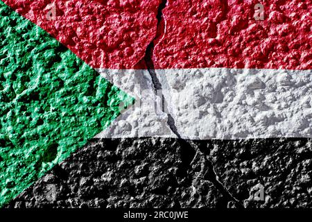 Flag of Sudan on the background of a plastered wall with a crack. Military insurgency and civil war in Sudan. Stock Photo