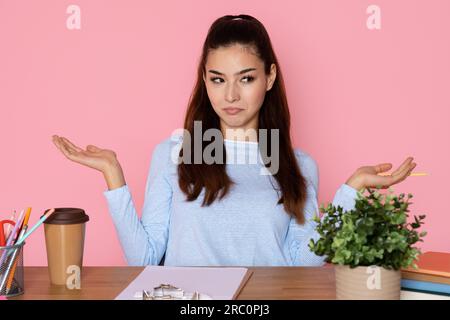 Enthusiastic pretty young woman employee sitting at workplace Stock Photo