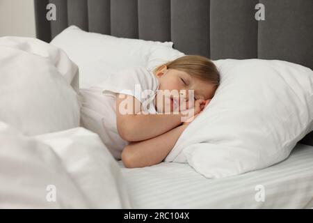 Little girl snoring while sleeping in bed Stock Photo