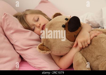 Little girl snoring while sleeping in bed Stock Photo