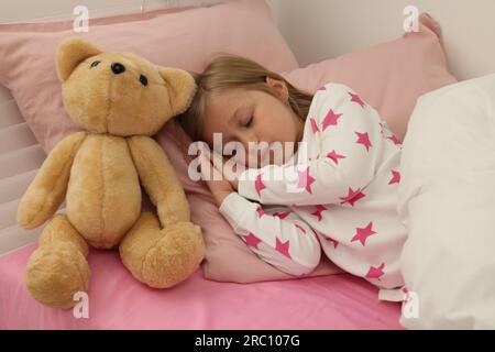 Little girl snoring while sleeping in bed Stock Photo