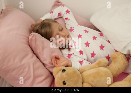 Little girl snoring while sleeping in bed Stock Photo