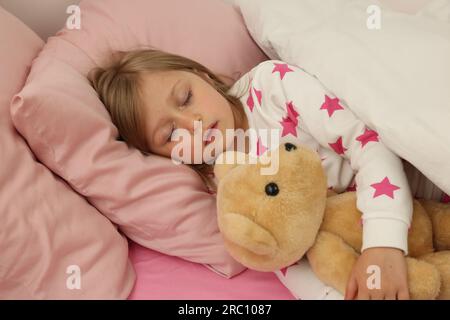 Little girl snoring while sleeping in bed Stock Photo