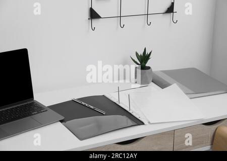 File folder with punched pockets on white table in office Stock Photo