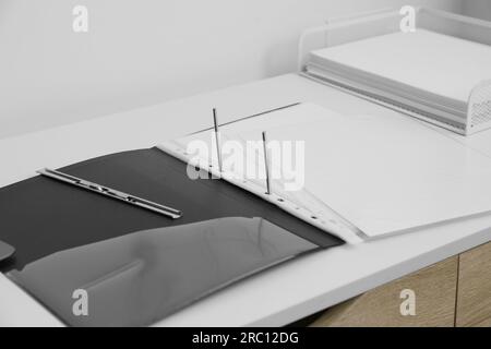 File folder with punched pockets on white table in office Stock Photo