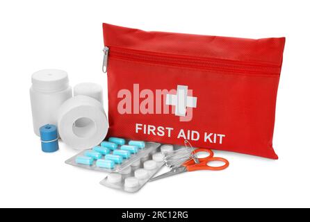 Red first aid kit, scissors, pins, pills, medical plaster and elastic bandage isolated on white Stock Photo