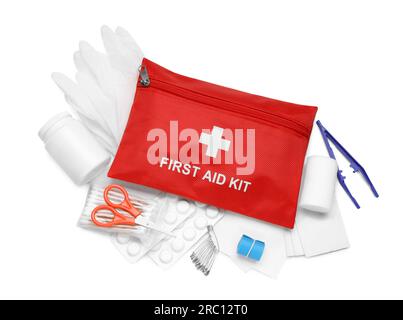 Red first aid kit, scissors, pins, gloves, cotton buds, pills, plastic forceps and elastic bandage isolated on white, top view Stock Photo