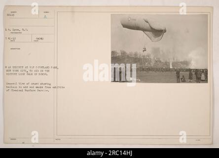 Image depicting a war exhibit at Van Cortland Park in New York City, aimed to support the sale of Victory Loan bonds during World War One. The photograph shows a general view of the crowd, with a balloon in the air and smoke from exhibits of the Chemical Warfare Service. Taken by Lt. Lyon, S.C., photographer 542-19. Description symbol: A 44949. Notes: 1299 48116 B. Stock Photo