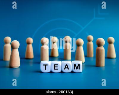 Team, teamwork, leadership and family business concepts. Words "TEAM", text on white cube blocks and different wooden people figures standing in front Stock Photo