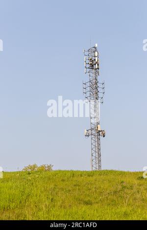 Cellphone tower - cellular phone transmission tower - grass hill background. Taken in Toronto, Canada. Stock Photo