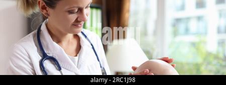 Female doctor examines male patient with hair loss problem at consultation in clinic. Stock Photo