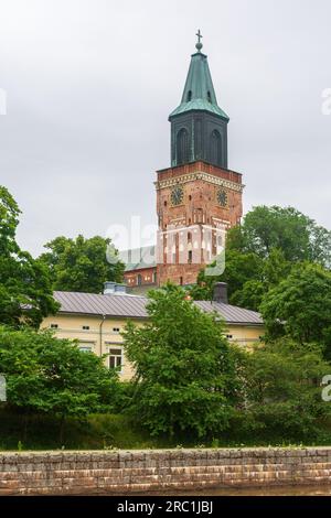 Cathedral bell tower behind yellow wooden house in Turku Finland Stock Photo