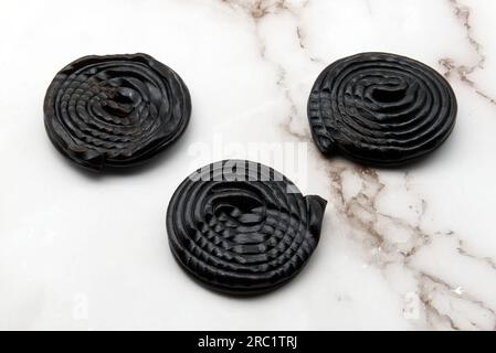 Tasty black licorice candies on white marble background Stock Photo