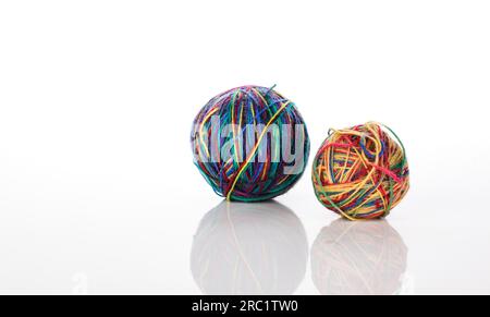 Two multicoloured wool balls on a white background with soft reflection Stock Photo
