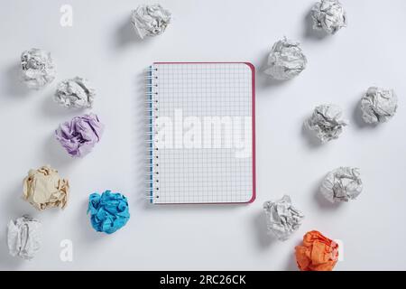 Notebook and paper balls on white background, top view Stock Photo