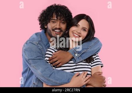 International dating. Lovely couple hugging on pink background Stock Photo