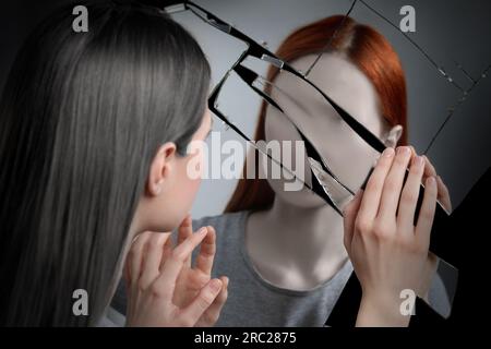 Suffering from hallucinations. Woman seeing her faceless reflection in broken mirror Stock Photo
