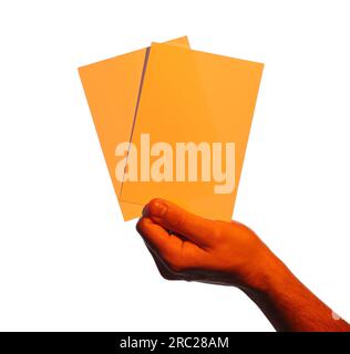 Man holding orange flyers on white background, closeup. Mockup for design Stock Photo