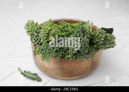 Bowl with fresh raw broccolini on white table, closeup. Healthy food Stock Photo