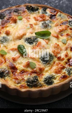 Delicious homemade quiche with salmon and broccoli on table Stock Photo