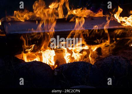 Campfire flame in the dark. Visible flames and hot coals. Close-up. Stock Photo