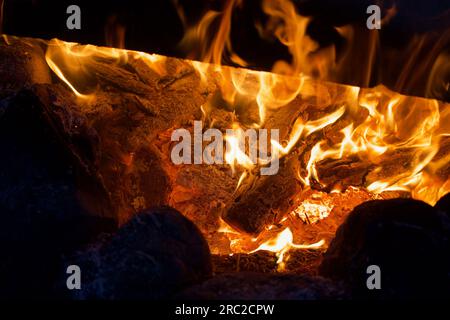 Campfire flame in the dark. Visible flames and hot coals. Close-up. Stock Photo
