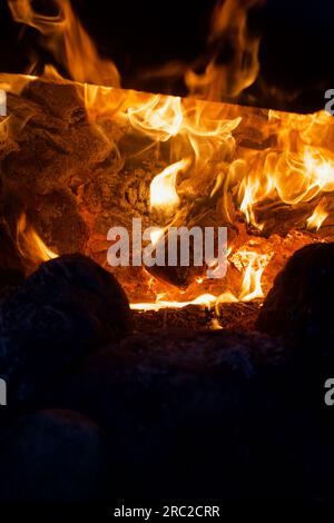 Campfire flame in the dark. Visible flames and hot coals. Close-up. Stock Photo