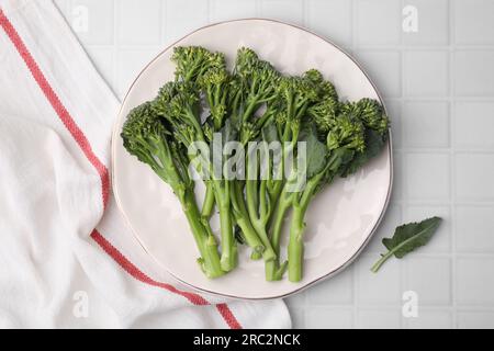 Fresh raw broccolini on white tiled table, top view. Healthy food Stock Photo