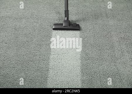 Vacuuming grey carpet. Clean area after using device. Space for text Stock Photo