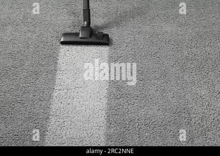 Vacuuming grey carpet. Clean area after using device. Space for text Stock Photo